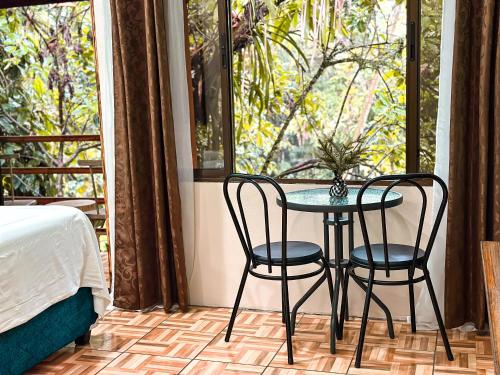 a table and two chairs in a room with a window at Cabañas Río Escondido en La Fortuna in Fortuna