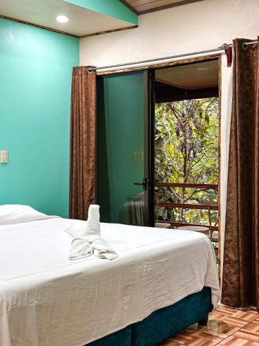 a bedroom with a bed and a sliding glass door at Cabañas Río Escondido en La Fortuna in Fortuna