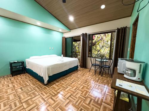 a bedroom with a bed and a tv in a room at Cabañas Río Escondido en La Fortuna in Fortuna