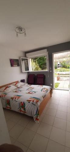 une chambre avec un lit et une grande fenêtre dans l'établissement Les Cygnes, à Criel-sur-Mer