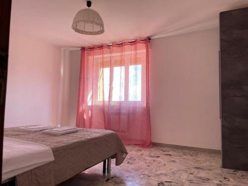 a bedroom with a bed and a window with red curtains at Casa Felice in Senigallia