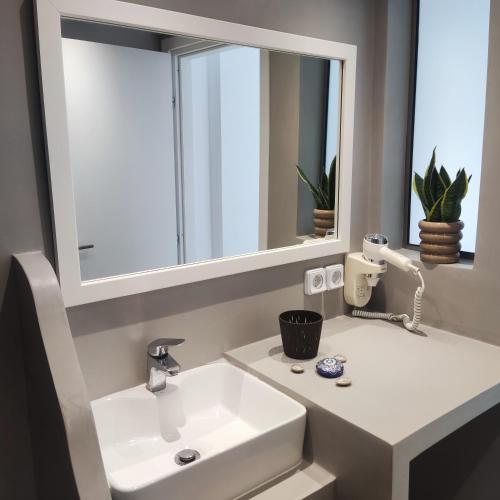 a bathroom with a white sink and a mirror at Il Margio Studio in Tinos Town
