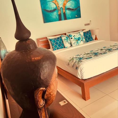 a bedroom with a bed and a vase in a chair at Samui Sunset 22G in Choeng Mon Beach