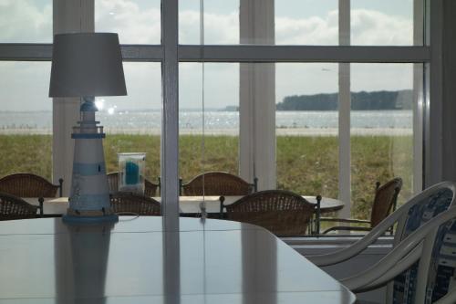 a dining room with a table and chairs and a lighthouse at Strandhaus direkt am Meer in Haderslev