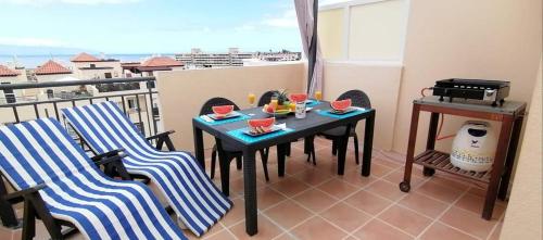 a balcony with a table and chairs on a balcony at Chilly Apartment - Sunny rooftop terrace with ocean view in Callao Salvaje