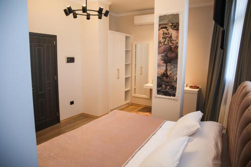 a bedroom with a bed and a painting on the wall at Sky Hotel Korce in Korçë