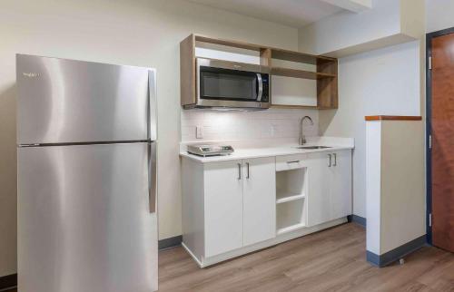 a kitchen with a stainless steel refrigerator and white cabinets at Extended Stay America Premier Suites - Pittsburgh - Cranberry Township - I-76 in Cranberry Township