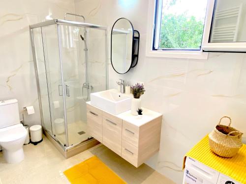 Un baño blanco con ducha y lavabo. en Riverside apartments, en Lefkada