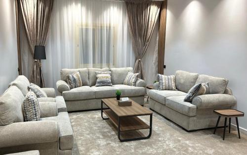 a living room with two couches and a coffee table at شقة فندقيه Happy Season in Hajlah