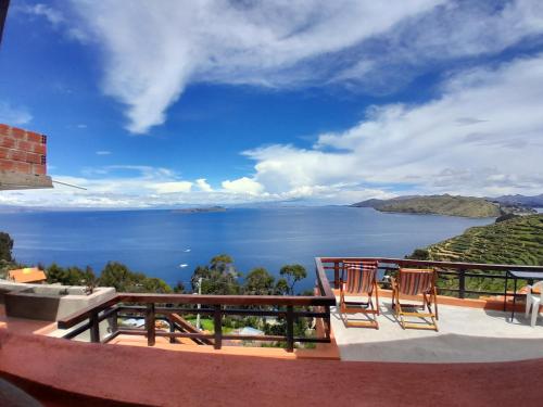 un balcone con due sedie e vista sull'oceano di Casa Andina - ISLA DEL SOL a Comunidad Yumani