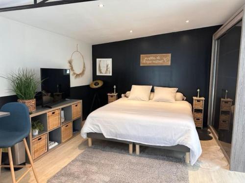 a bedroom with a bed and a black wall at Le Refuge Votre Havre de Paix in Clermont-Ferrand