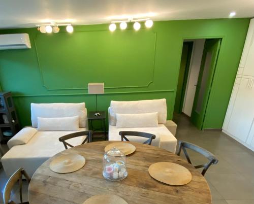 Cette chambre comprend une table et un mur vert. dans l'établissement 200 from Martines and Boulevard de la Croisette, à Cannes