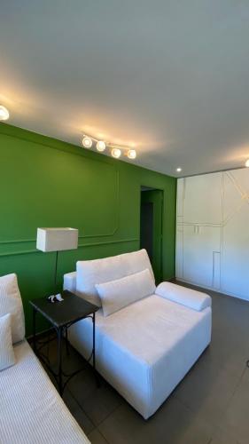une chambre avec un lit blanc et un mur vert dans l'établissement 200 from Martines and Boulevard de la Croisette, à Cannes