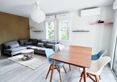 un salon avec une table, des chaises et un canapé dans l'établissement Pins & Lacs, à Biscarrosse