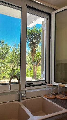 a kitchen with a sink and a large window at Riverside apartments in Lefkada