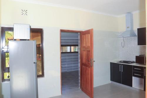 a kitchen with a refrigerator next to a door at Kabuchai Villa in Bungoma
