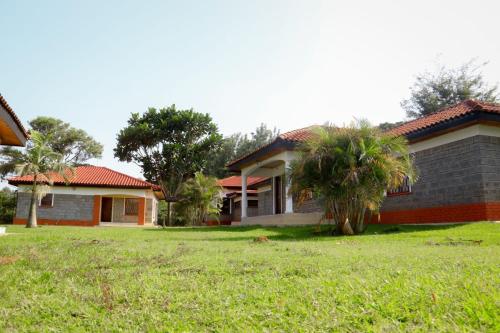 a house with a grass yard in front of it at Kabuchai Villa in Bungoma