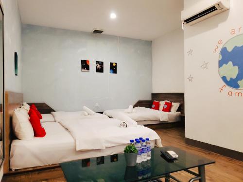 a living room with two beds and a table at Winggarden Murals House by JE Boutique Guesthouse in Ipoh