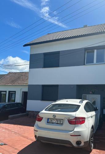 a white car parked in front of a house at Ubytování U Dědy in Moravská Nová Ves