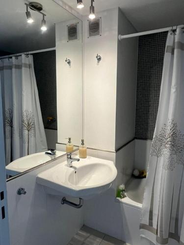 a white bathroom with a sink and a shower at Alojate en METRA Puerto Norte, luminoso estudio con pileta, gym y balcon in Rosario