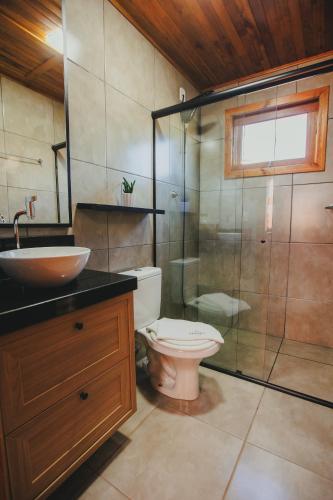 a bathroom with a toilet and a sink and a shower at Recanto da Maju in Bom Jardim da Serra