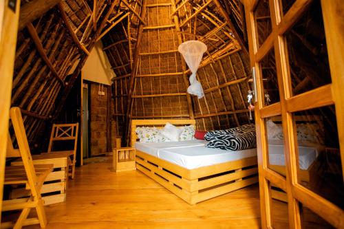 a bedroom with a bed in a straw hut at Moshi hostel lodge in Msaranga