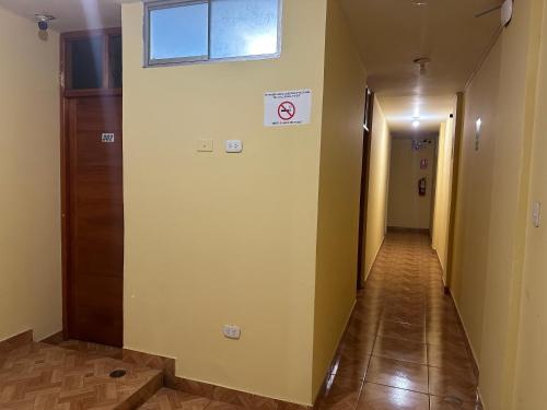 un pasillo con una puerta y una señal de no fumadores en Hospedaje San Rafael en Tarapoto