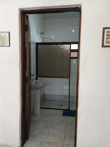 a bathroom with a sink and a toilet and a mirror at Renovo Beija-flor Hostel e Espaço Terapêutico in Bertioga