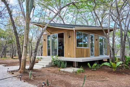 a tiny house in the woods with trees at SURÁ Playa Negra in Playa Negra