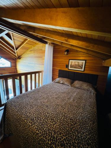 a bedroom with a bed in a wooden room at Recanto Ar da Serra in São Joaquim