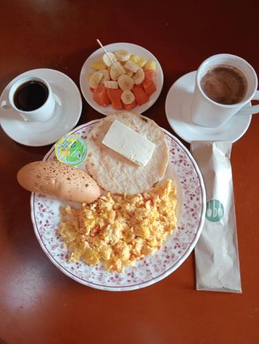 a table with a plate of breakfast food and a cup of coffee at Hotel Campestre Alto Bonito del Quindío in El Cuzco