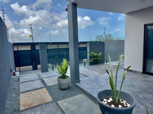 a patio with two potted plants on a building at Belíssima casa no Preá in Cruz