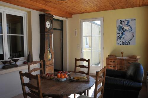une salle à manger avec une table et une horloge dans l'établissement Maison de famille rustique Durée de location 7 jours minimum, à Saint-Michel-des-Andaines