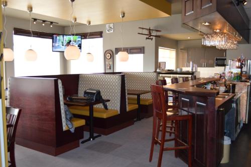 a bar in a restaurant with chairs and tables at Hôtel Maison Blanche in New Carlisle