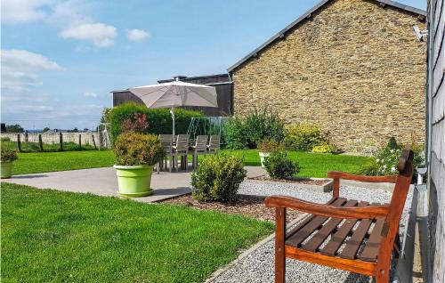 a wooden bench with an umbrella in a garden at Nadrin O Vert in Nadrin
