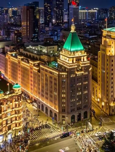 a view of a building with a green roof at night at Fairmont Peace Hotel on the Bund in Shanghai