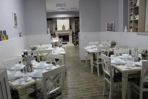 a room with white tables and chairs with flowers on them at Villa Paris in Hisarya