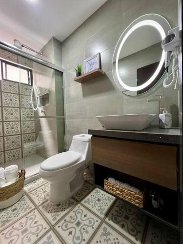 a bathroom with a toilet and a sink and a mirror at Tinta & hierro Suite 2 in Loja