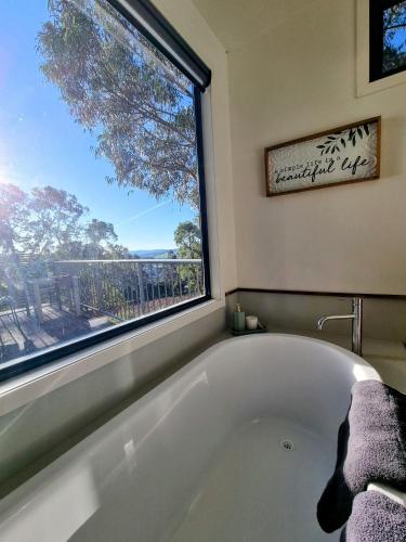 a bath tub in a bathroom with a window at Vineyard Haven in Grindelwald