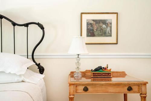 a bedroom with a bed and a table with a lamp at Villa Emery in Water Mill