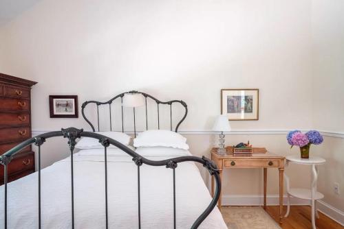 a bedroom with a bed and a wooden table at Villa Emery in Water Mill