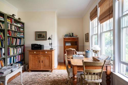 a dining room with a table and a book shelf at Villa Emery in Water Mill