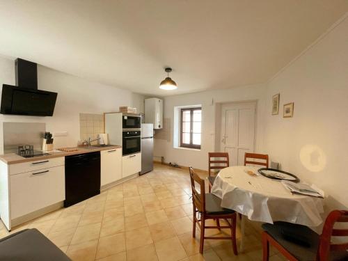 une cuisine et une salle à manger avec une table et une table et des chaises dans l'établissement Gîte tout inclus avec jardin, clim, Wifi, proche Château de Villandry et Loire à vélo - FR-1-381-587, à Villandry