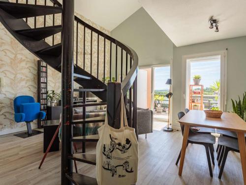 un escalier en colimaçon dans un salon avec une guitare dans l'établissement Bel appartement duplex à Ciboure avec terrasse proche golf Nivelle - FR-1-4-696, à Ciboure