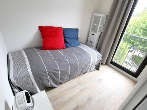 - une chambre avec un lit doté d'un oreiller rouge et bleu dans l'établissement T2 rénové avec parking, Wi-Fi, clim mobile, à 400m plages/commerces - Piscine/tennis/promenades - FR-1-316-338, à Six-Fours-les-Plages