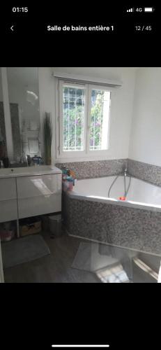 une salle de bain avec une baignoire, un lavabo et une fenêtre dans l'établissement Villa style Ibiza 3 chambres, vue mer jacuzzi, à Mandelieu-la-Napoule