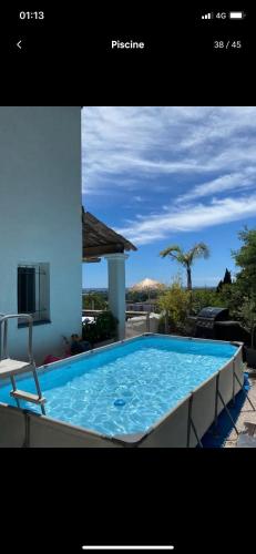 une grande piscine bleue avec une chaise à côté d'un bâtiment dans l'établissement Villa style Ibiza 3 chambres, vue mer jacuzzi, à Mandelieu-la-Napoule