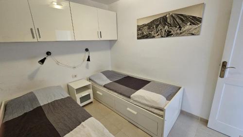 a small bedroom with two beds in it at Paraiso Achacay, see view los cristianos in Los Cristianos