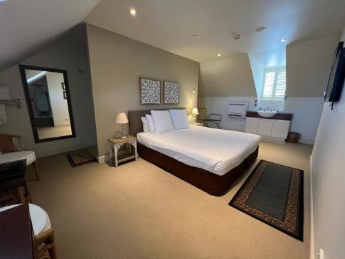 a bedroom with a large bed and a bathroom at Fitzroy Inn Historic Retreat Mittagong in Mittagong