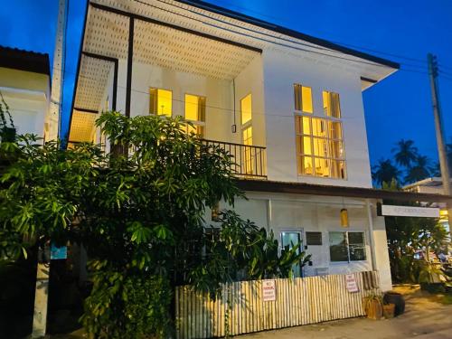 a white house with a tree in front of it at Villa Wonderworld Resort in Ban Nua